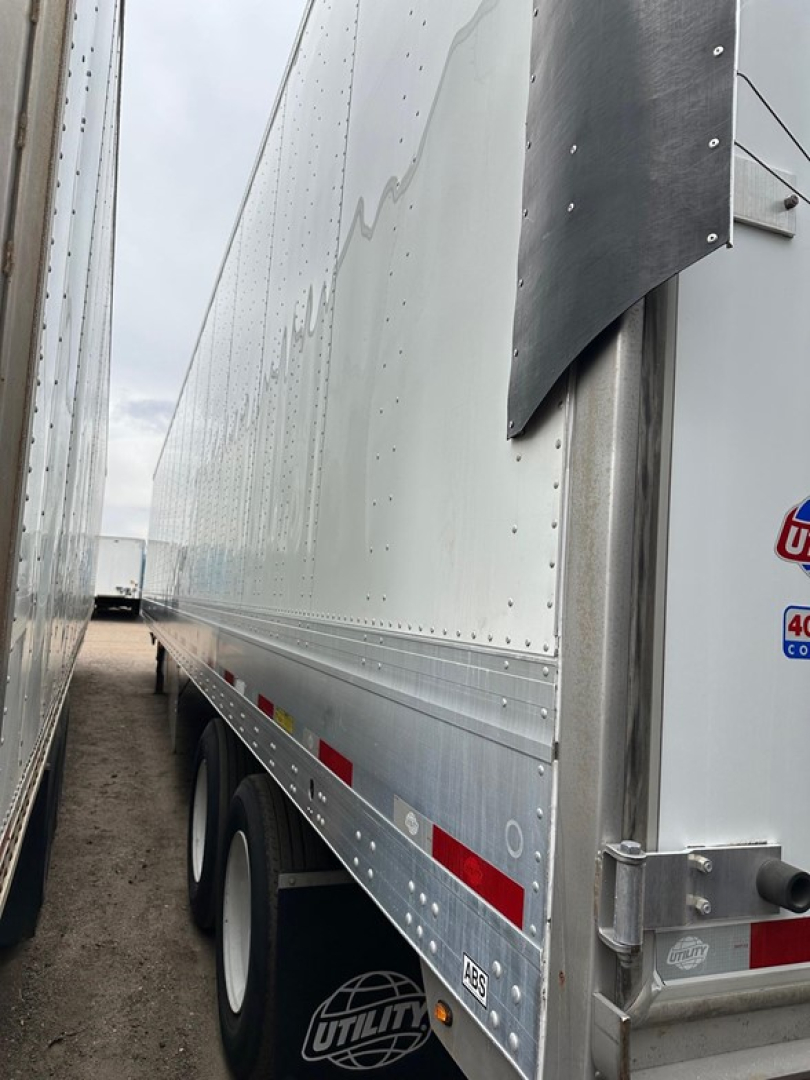Utility 4000Dx trailer side view showing riveted aluminum wall, corner corner post, and wheel set with dual axles.