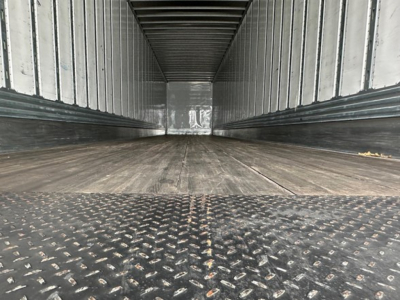 Trailer interior of a Utility 4000Dx showing long cargo bay with diamond plate steel at entry and ribbed sidewalls.