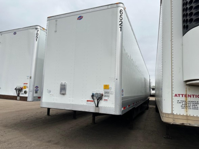 Trailer rear/side view of a white Utility 4000DX dry van trailer showing back doors and bumper area.
