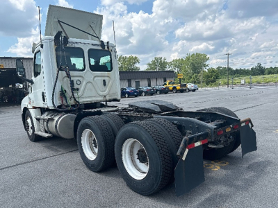 Truck chassis of a Freightliner Cascadia 126 with dual rear axles and fifth-wheel area visible, used-condition in a lot.