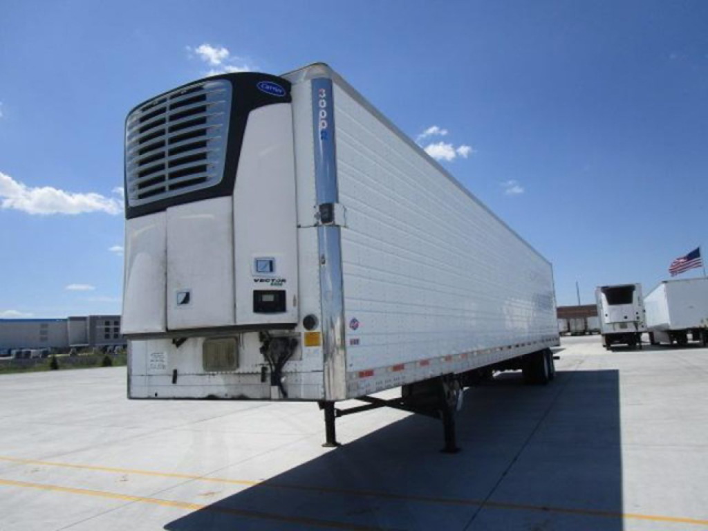 2013 utility refrigerated trailer with trager doors and front refrigeration unit showing brand label and blue vertical reinforcement, parked in lot.