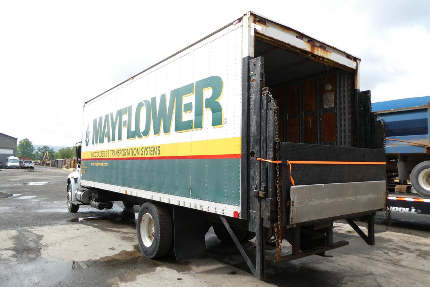 International 4300 SBA box truck with Mayflower trailer and open rear cargo area.