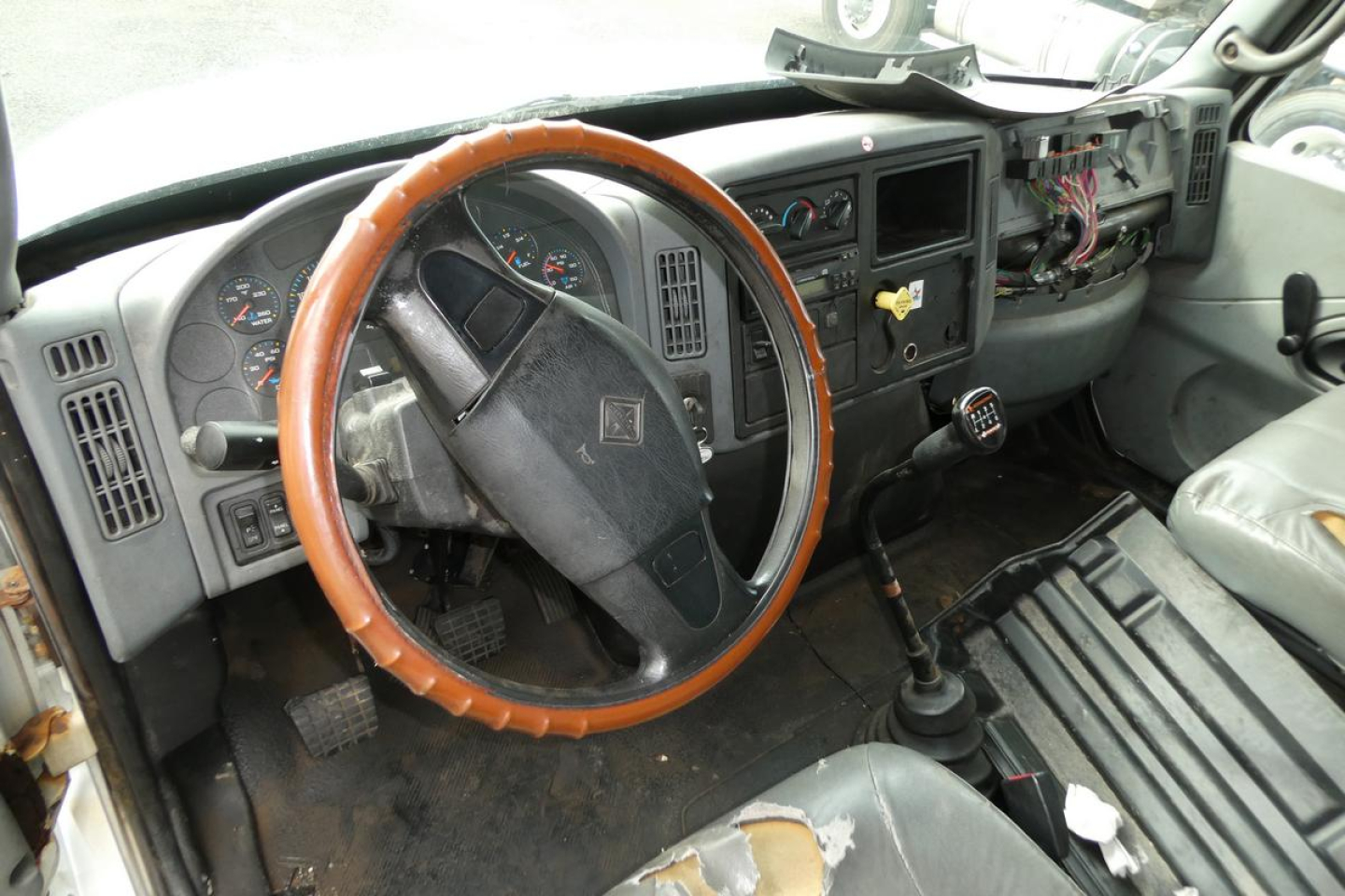 Cab interior of 2006 International 4300 SBA truck showing steering wheel, dashboard, and gear shifter.