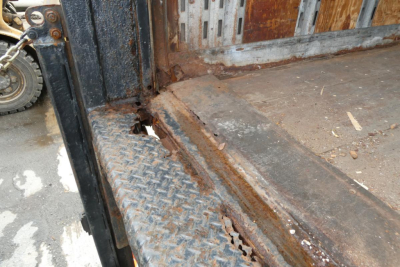 Rear cargo area of a 2006 International 4300 SBA with visible rust and damaged cargo bed edge.