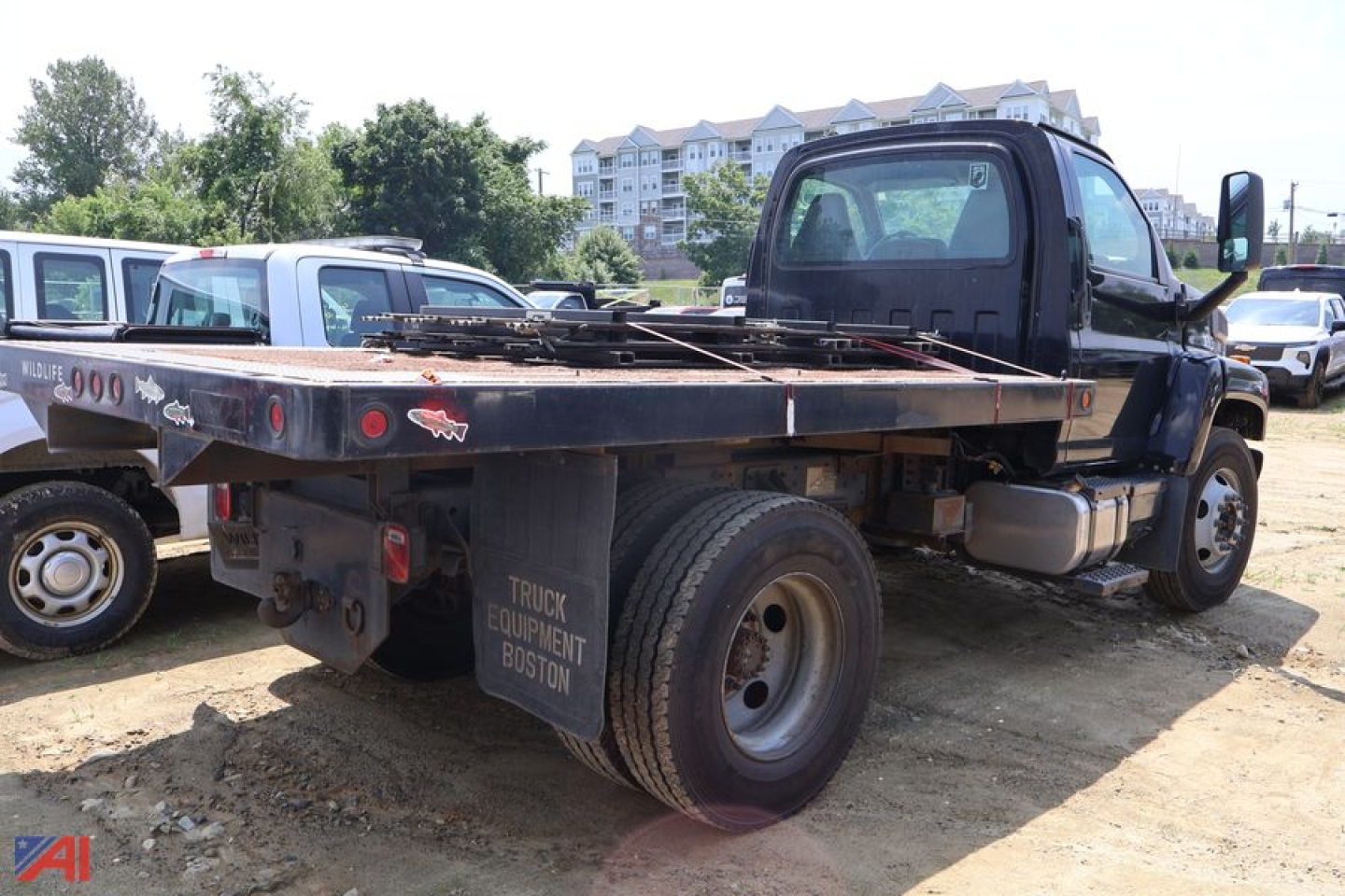 Truck bed of a 2005 Chevrolet Kodiak C7500 stake dump showing rear wheels and flatbed with truck equipment Boston mud flaps.