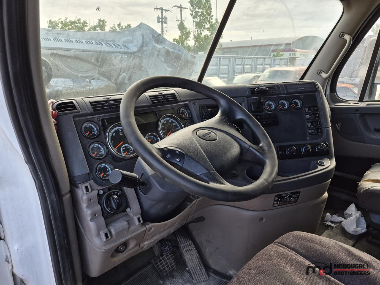 Dashboard and steering wheel area of a Freightliner Cascadia truck cab showing instrument cluster and control panels.