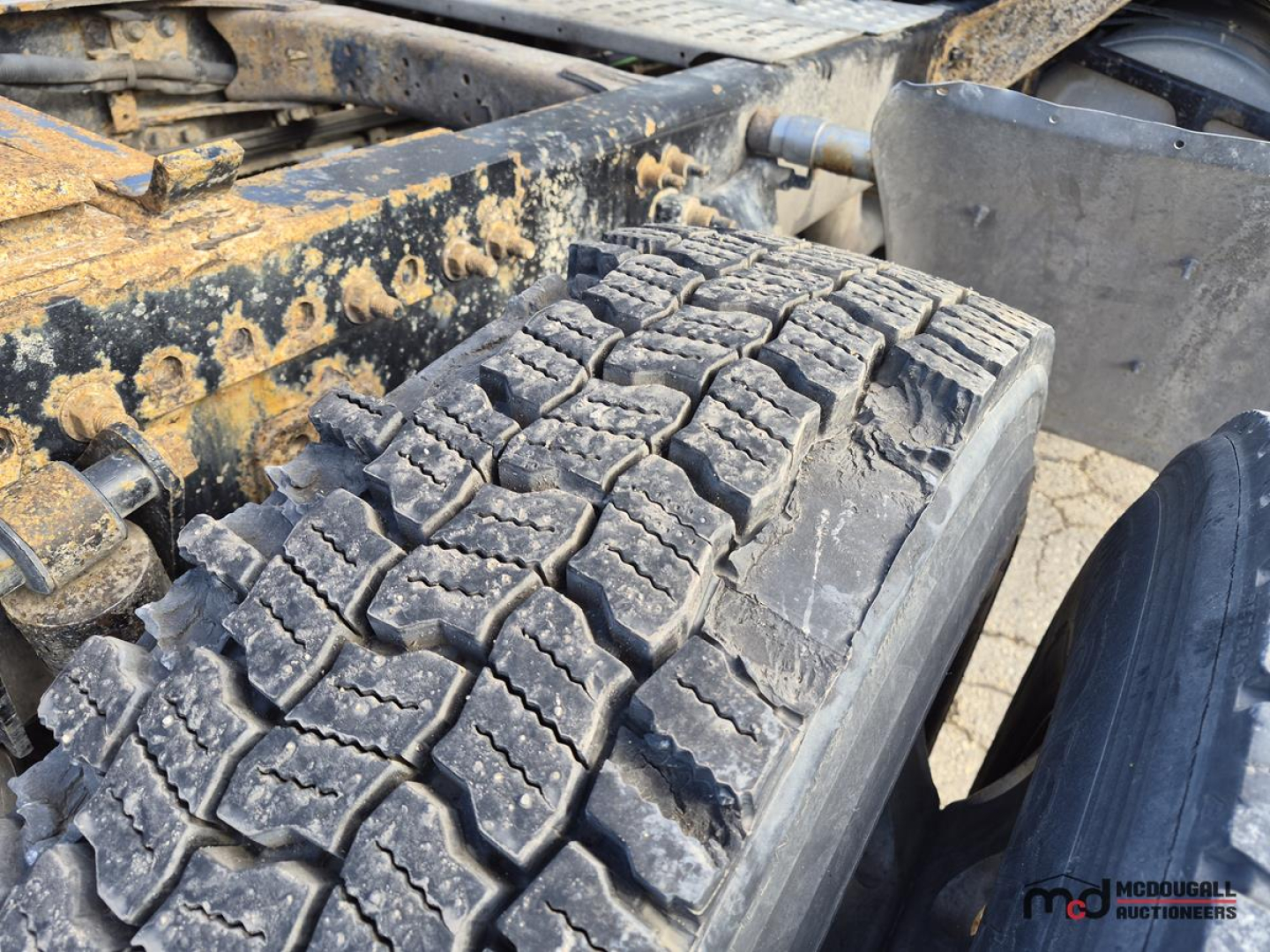 Tire tread and undercarriage of 2016 Freightliner Cascadia tractor showing heavy-duty lug pattern and frame components.