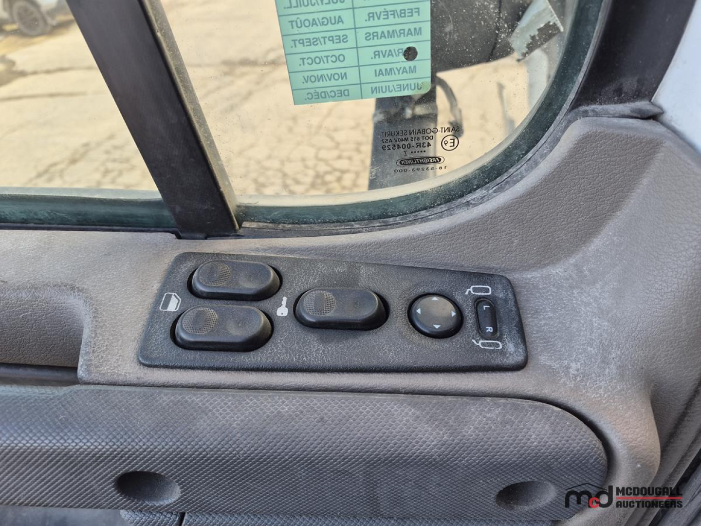 Cab window controls and interior door panel of a Freightliner Cascadia truck showing power window/lock switches.