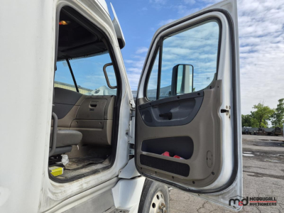 Freightliner Cascadia 2016 cab interior with open door showing front seat area and open driver door; interior panels and dashboard visible.