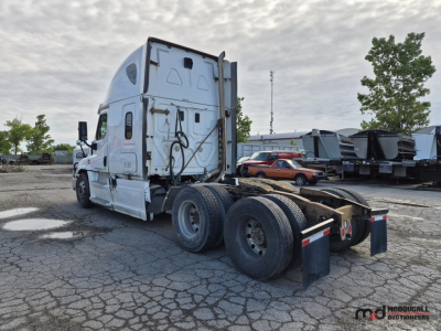 Truck tractor from rear three-quarter view showing sleeper cab, tandem axles, and fifth-wheel area.