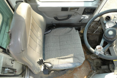 Operator cabin of a Kalmar Ottawa YT30 yard truck showing steering wheel, seat with wear, and control console