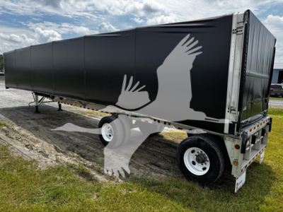 Trailer side view showing black curtain side with white silhouette artwork and rear wheels on a used 2018 Reitnouer Big Bubba curtainside trailer.