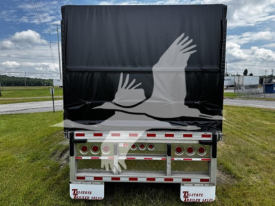 Rear view of 2018 Reitnouer Big Bubba curtainside trailer with black tarp and decorative white bird graphic, showing rear lights, bumper, and reflection.