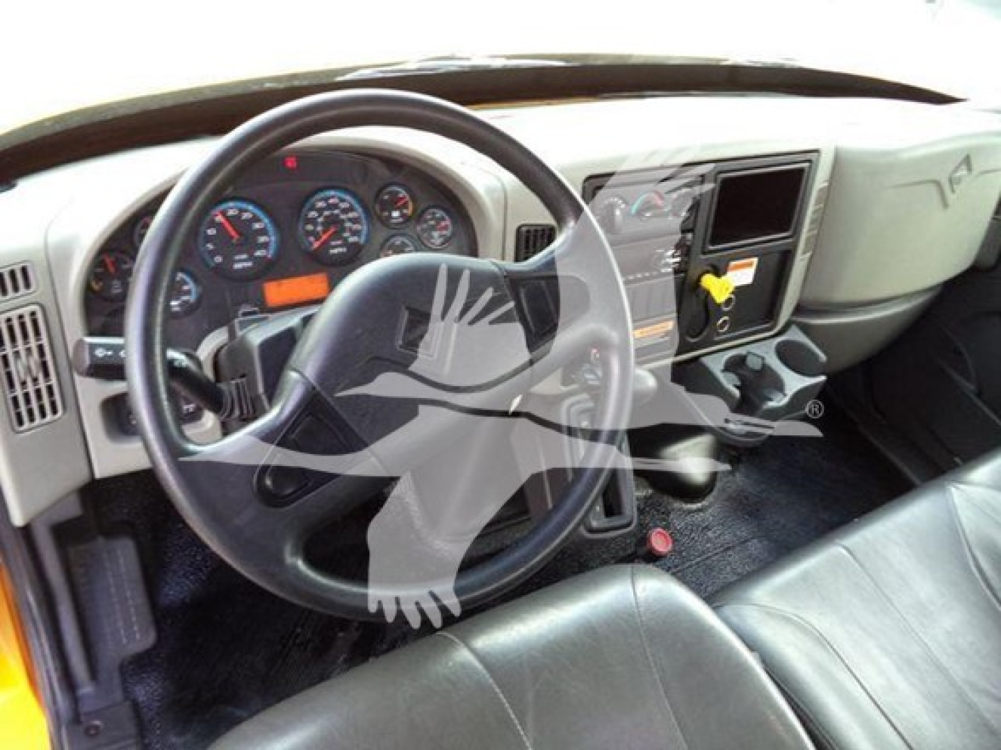 Truck cab interior showing steering wheel, dashboard gauges, and center console of a 2019 International Durastar grapple truck.