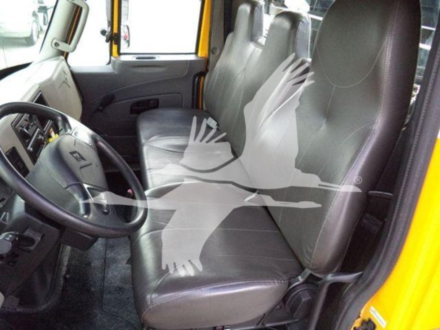 Grapple truck cab interior of 2019 International Durastar showing driver seat and front passenger seats with steering wheel and dashboard visible.