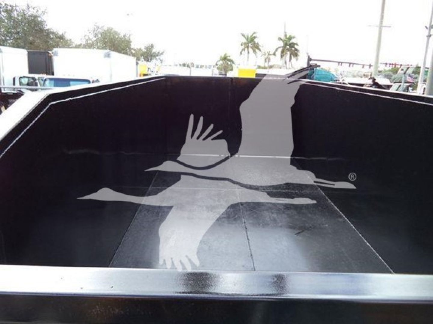 Truck bed interior of a 2019 International Durastar grapple truck showing metal walls and a spray-coated bed. 