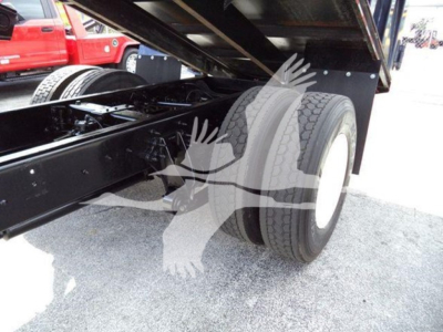Truck rear dual wheels and undercarriage showing suspension frame and dump bed with hydraulic support.