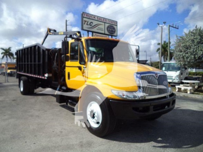 Truck showing yellow International Durastar grapple body with black crane arm and dump bed, front view, stock number T14931.