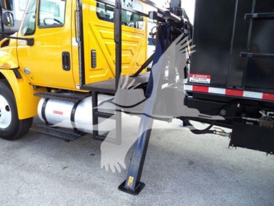 Truck side view showing a yellow International Durastar cab and a black grapple truck body with a mounted stabilizing jack at ground level.