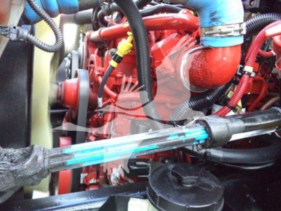 Engine bay of a 2019 International Durastar grapple truck showing red engine, blue hoses, and various black cables.