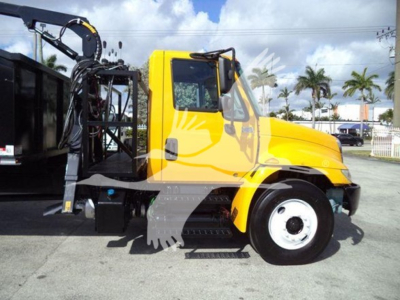 Truck side view of a yellow 2019 International Durastar grapple truck showing cab, front wheel, and grapple arm in back; VIN sticker and stock number not visible on this angle.