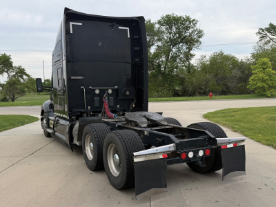 Kenworth T680 tractor rear view showing chassis and fifth wheel with dual rear axles and mud flaps.