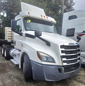Front view of a white 2019 Freightliner Cascadia day cab tandem, cab number '19' on windshield, chrome grille, large side mirrors, gray bumper, sleeperless cab.