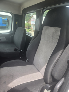 Cab interior of a 2019 Freightliner Cascadia day cab showing seats and windows.