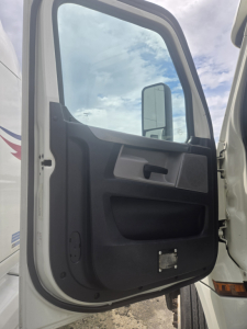 Truck cab door interior view of a 2019 Freightliner Cascadia Day Cab Tandem Class 8 showing the door panel and window.