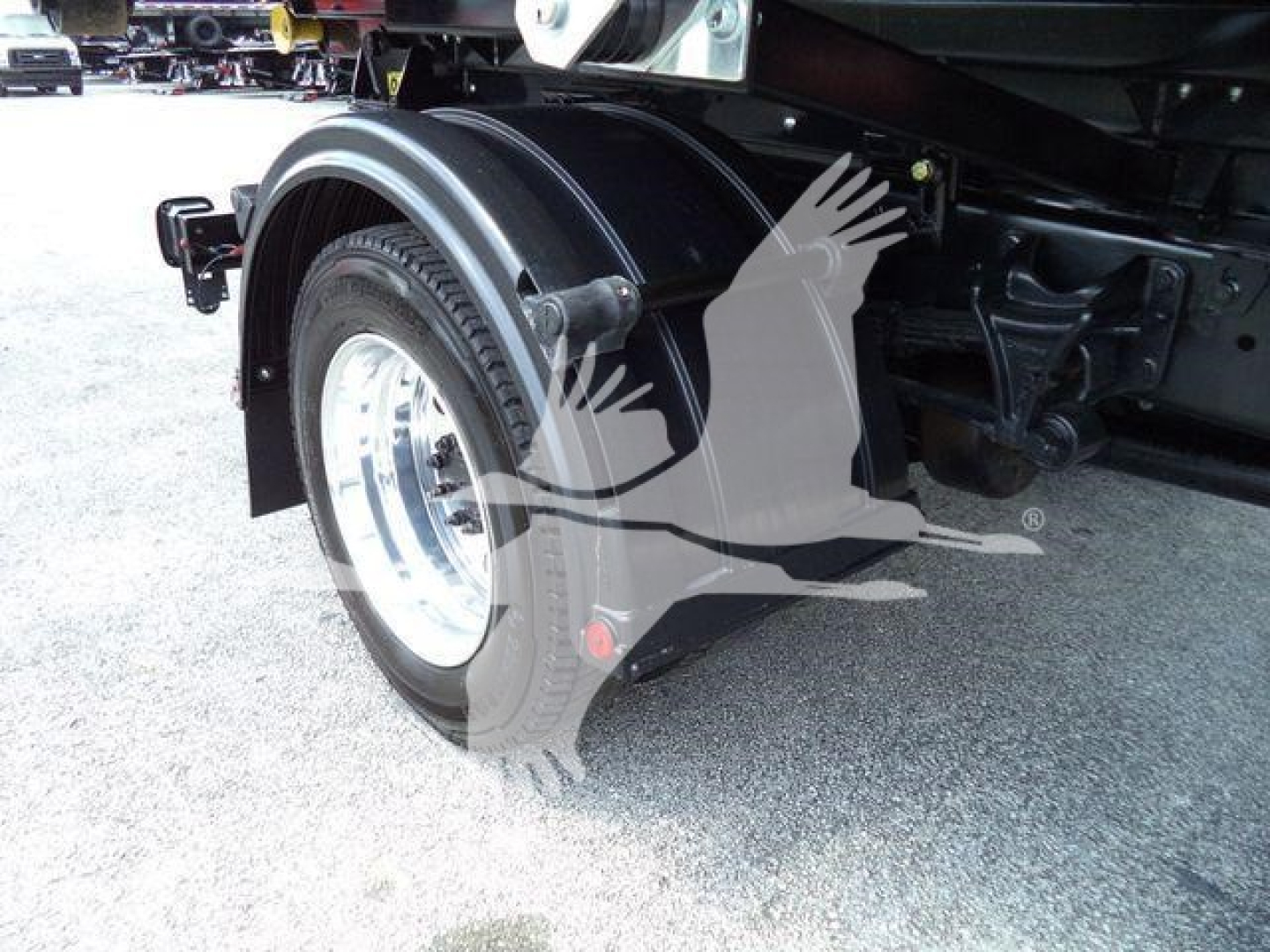 Front-right wheel and fender of a 2023 International CV roll-off truck showing wheel, fender, and undercarriage components.
