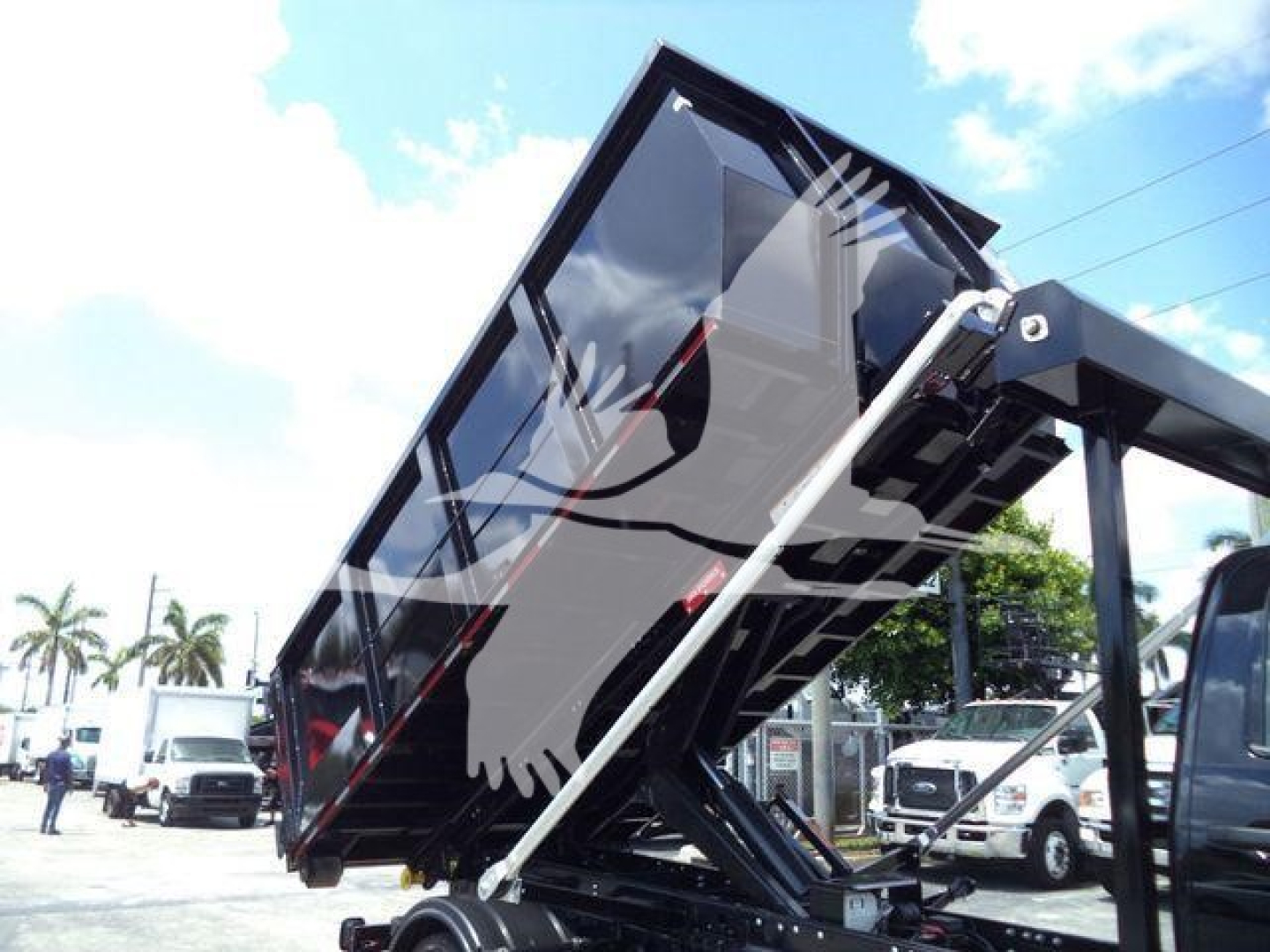 Trucks category showing new 2023 International CV roll-off truck with a raised dump body and hydraulic lifting mechanism.