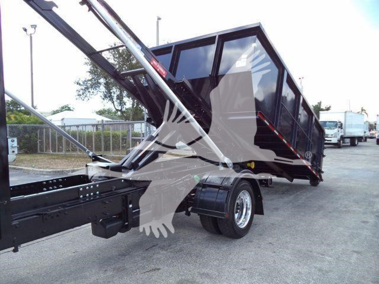 Hydraulic arm and roll-off truck bed on a 2023 International CV roll-off. Visible components include the dump bed with black paint, hydraulic cylinders, and dual rear wheels. Stock number CV515CREW14SNG2.