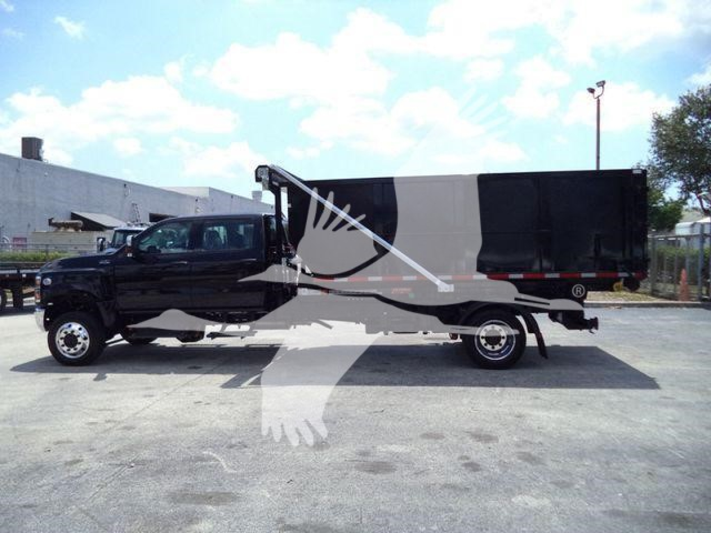 Rolloff truck in black with gray cargo container and white bird watermark visible.