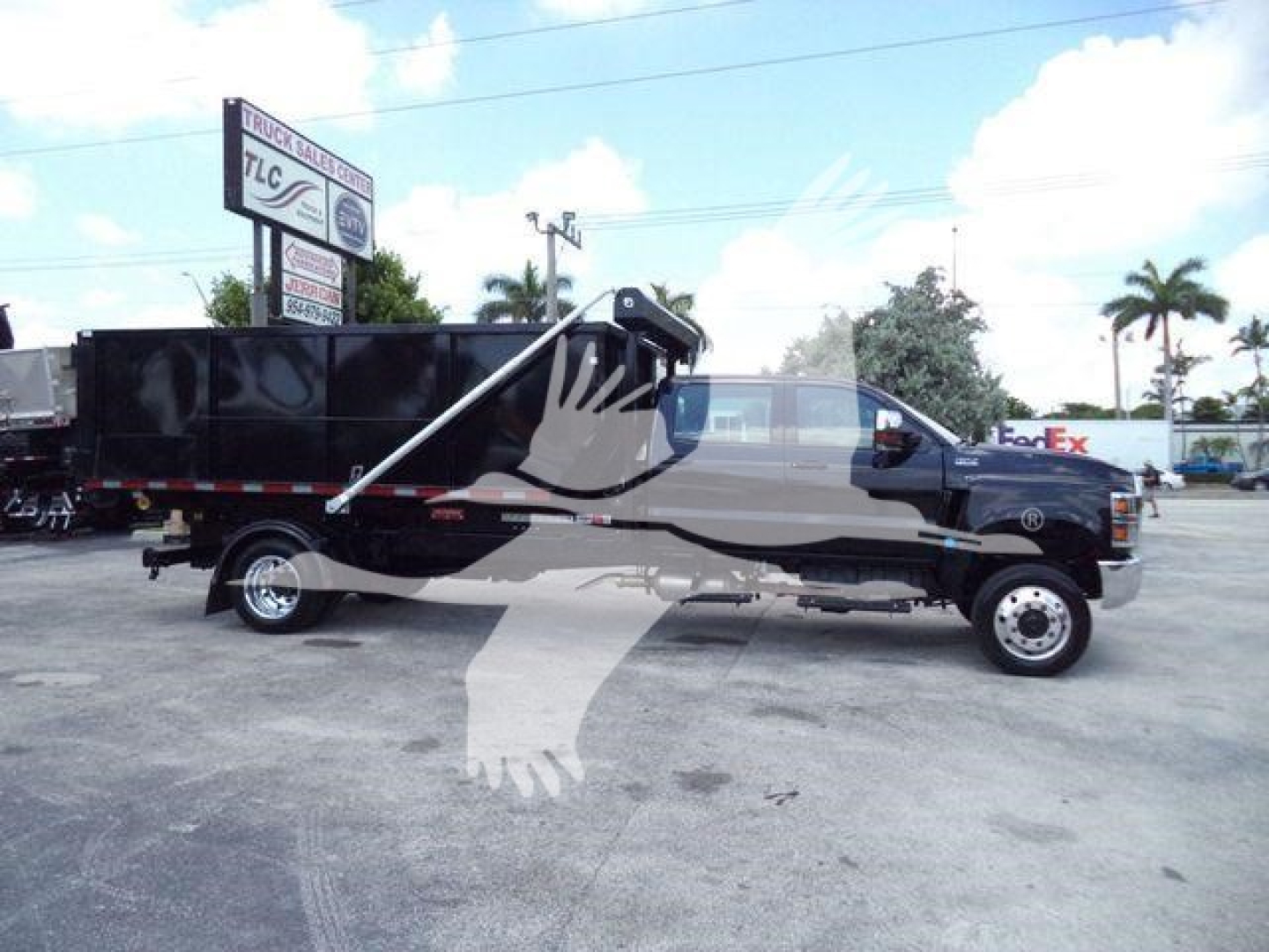 Engine bay not visible; truck side view of 2023 International CV roll-off with crane/dump bed in profile, black color, stock number CV515CREW14SNG2.