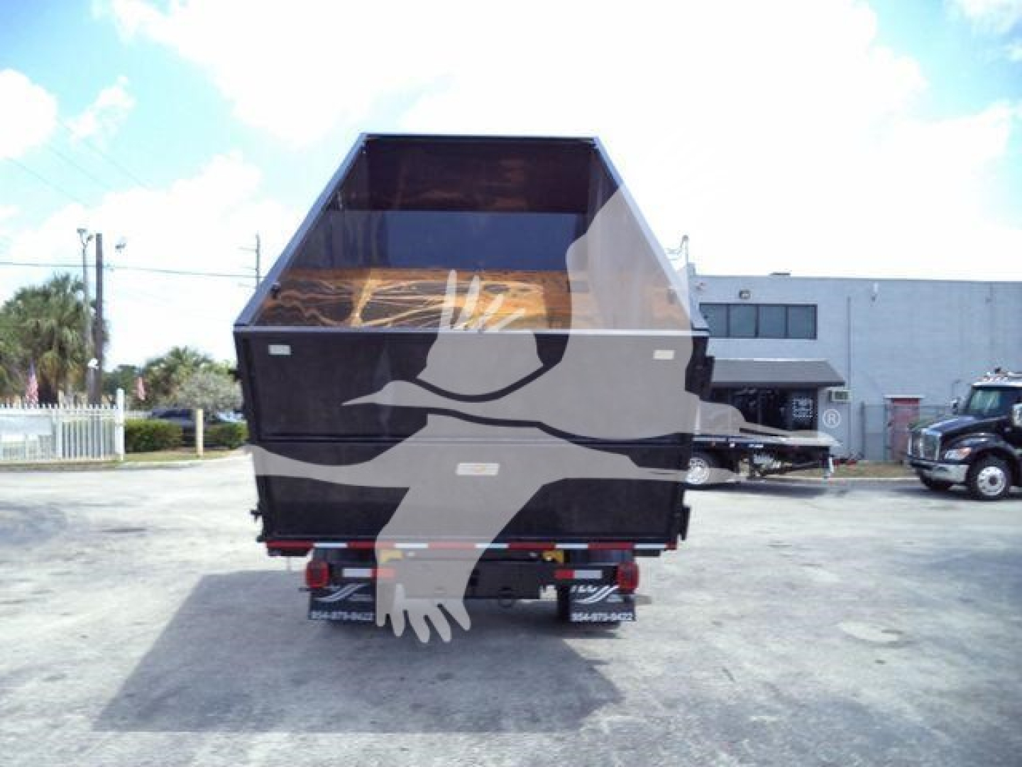 Dump truck bed and rear of a 2023 International CV roll-off truck showing cargo bed and rear wheels.