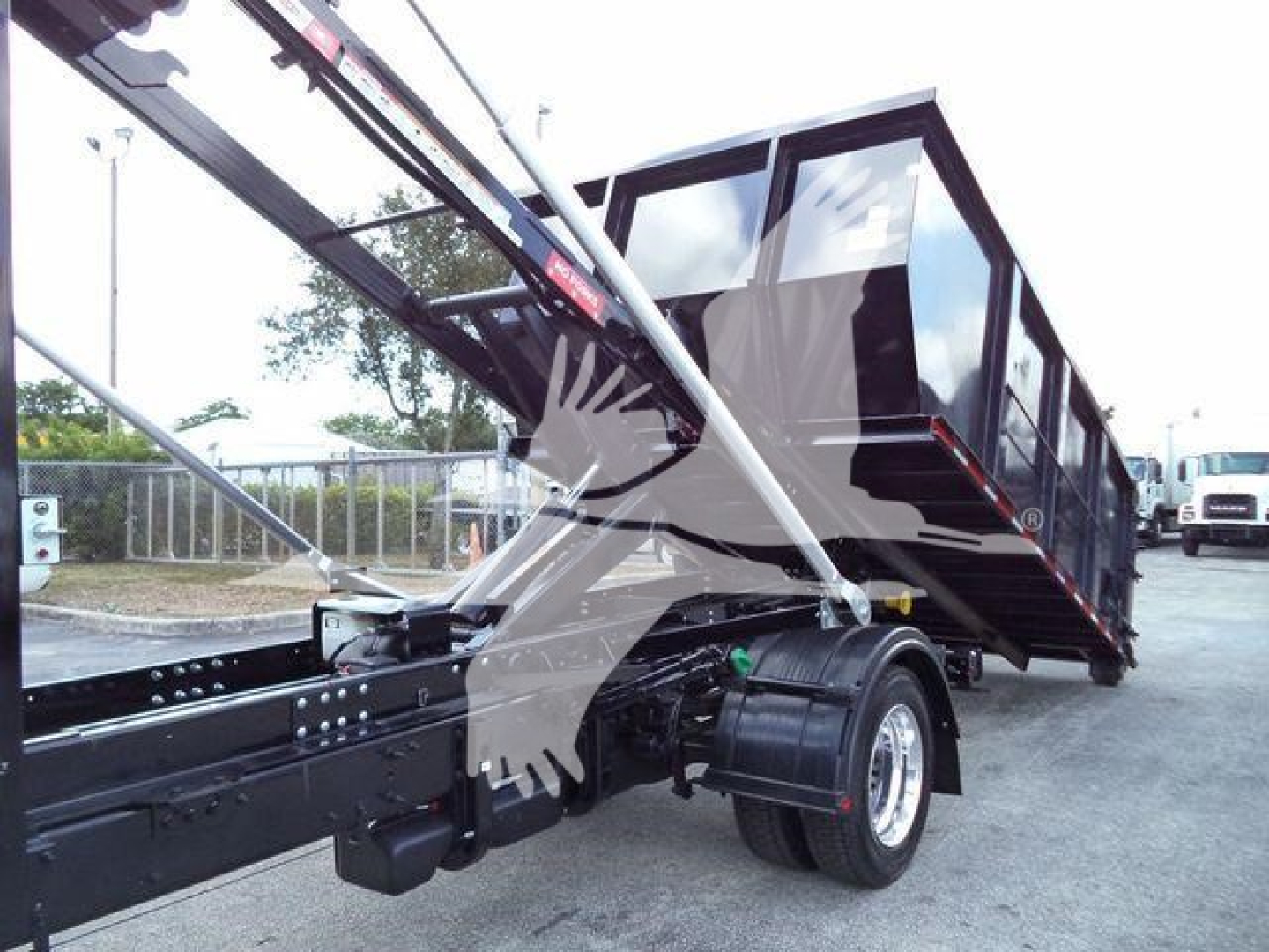 Dump truck trailer in side view showing black chassis with hydraulic lift arms and a large cargo bed.