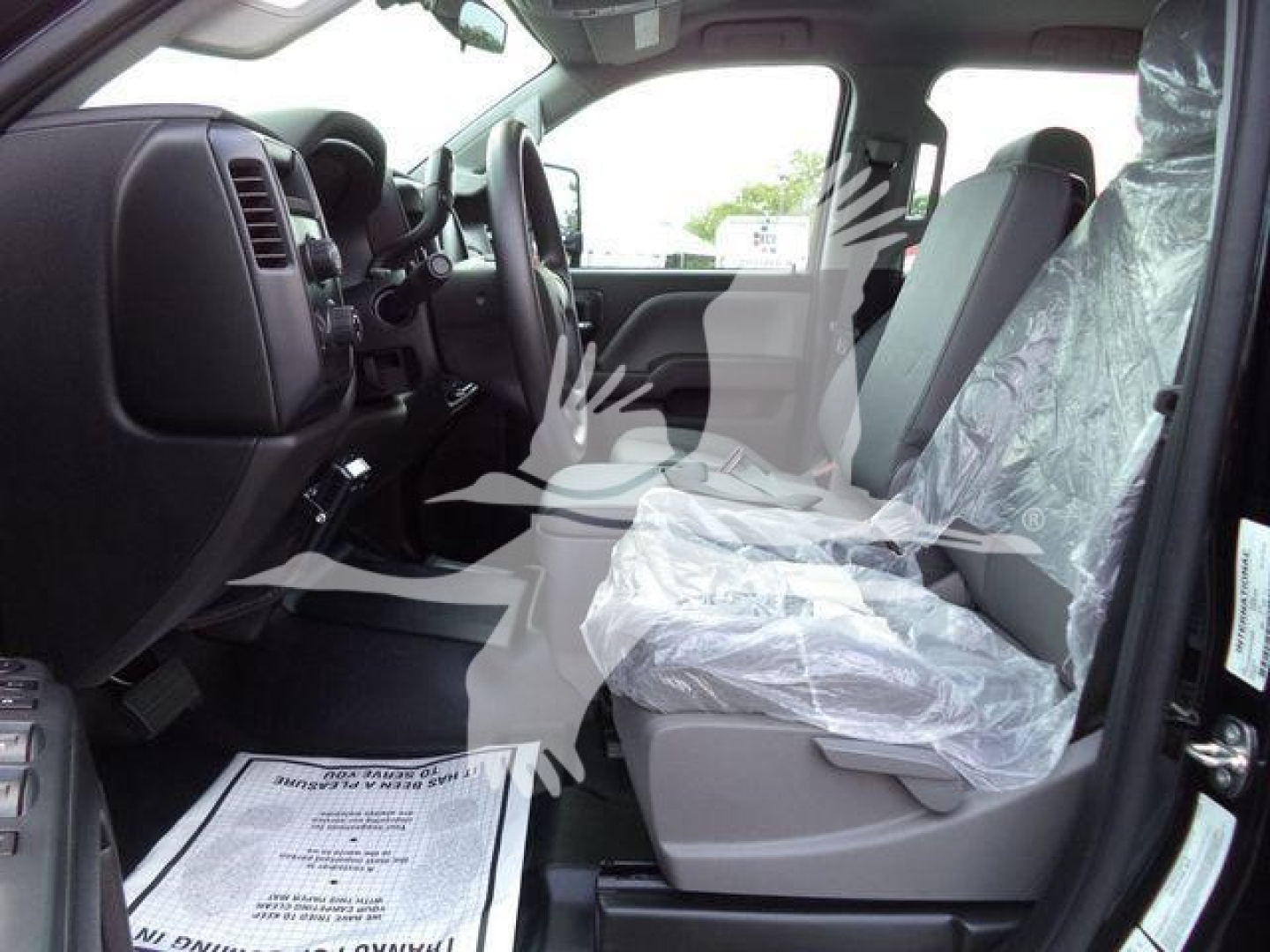 Truck interior showing front seats and dashboard with protective plastic on seats in a new International CV rolloff truck.
