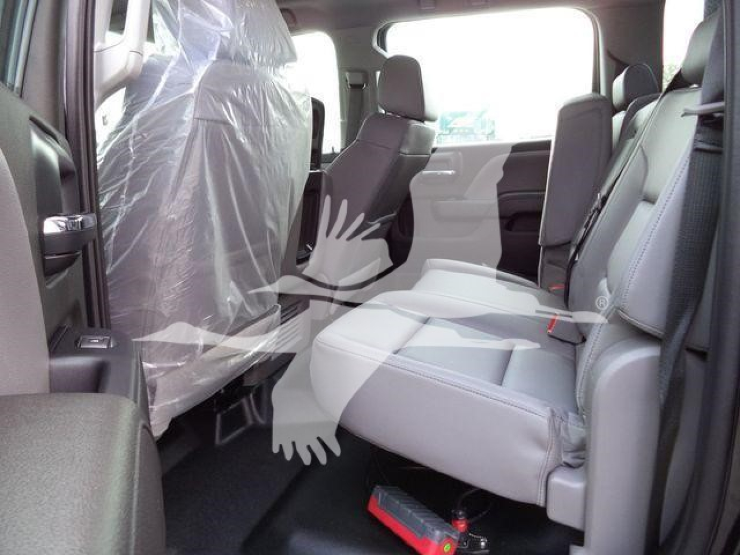 Truck interior: front and rear seats with plastic covering on the driver seat; light gray upholstery; center console and door panels visible.