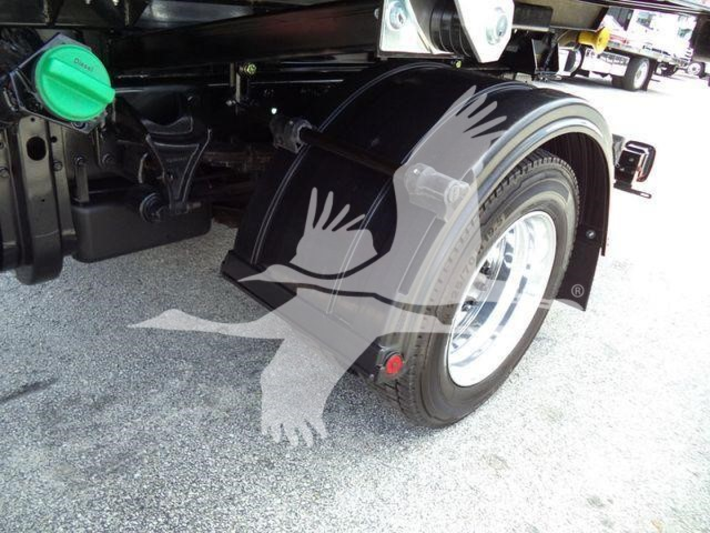 Truck rear wheel, fender and fuel filler cap visible; no legible labels or serials readable on image.