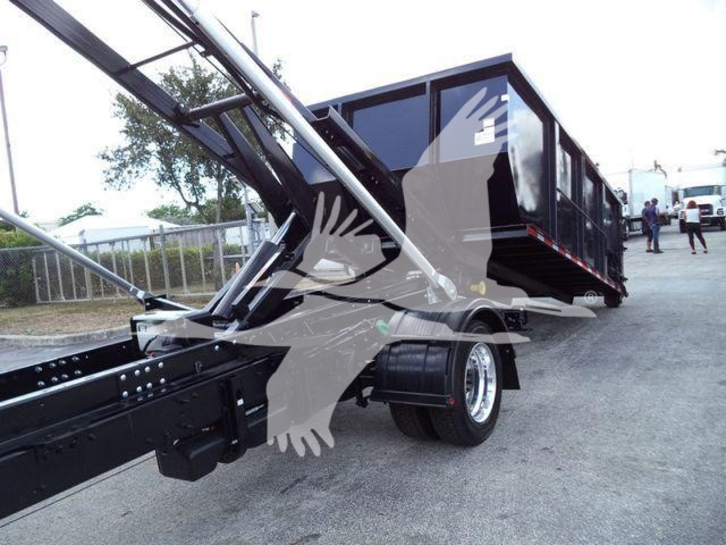 Truck bed and hoist assembly of a 2023 International CV roll-off truck showing the lifting mechanism and cargo container.