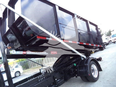 Dump truck side view showing black roll-off collection body with chrome frame and wheel, CV515CREW14SNG2 stock number visible.