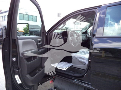 Interior view of a black 2023 International CV truck with front door open, showing steering wheel, dashboard, and driver’s seat. Some papers on the seat. Vehicle appears new.