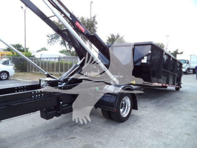 Truck mounted with crane arm showing rear cargo container and ballast in a lot.
