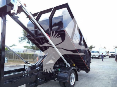 Truck truck bed dump hoist in raised position showing roll-off container chassis and hydraulic mechanism.