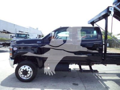 Truck side view showing a 2023 International CV roll-off body with black paint and crane equipment mounting on the rear, cab and chassis visible.