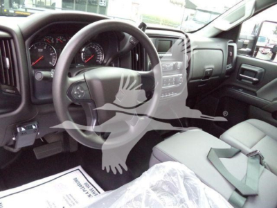 Interior cab of 2023 International CV roll-off truck showing steering wheel and dashboard with center touchscreen and gear area.