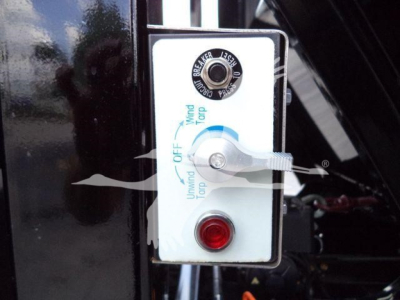 Truck control panel showing wind/turbine control switch and red indicator button on white face with label text.