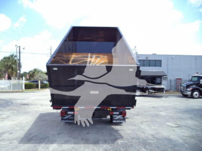 Dump truck bed and rear of a 2023 International CV roll-off truck showing cargo bed and rear wheels.