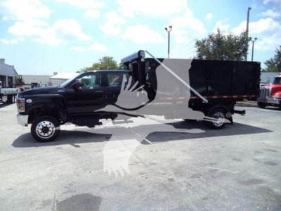 Truck cab and dump body in a dealership lot; black International CV-series roll-off truck with long dump body and dual rear wheels