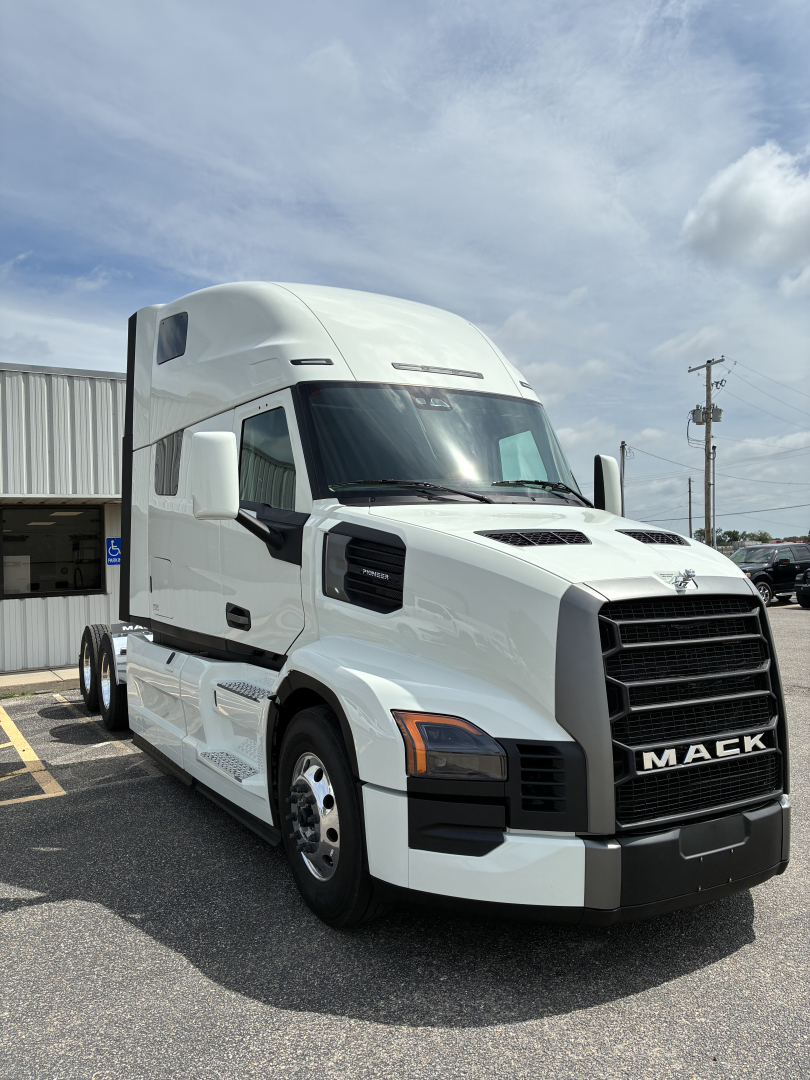 Mack PR64T76H conventional sleeper truck showing front grille with MACK branding and large side mirrors.